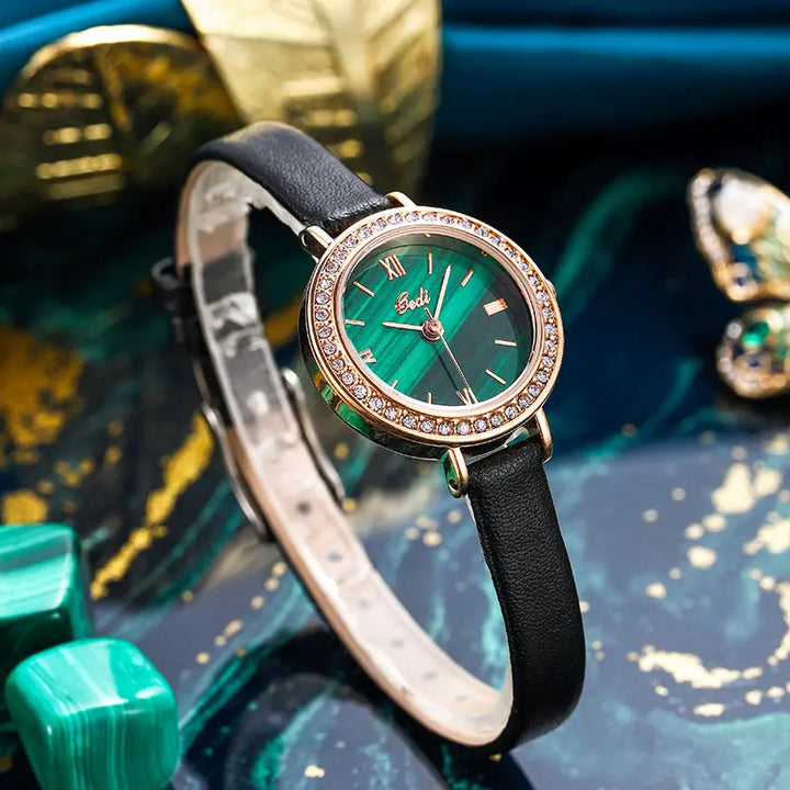 Elegant rose gold watch with a captivating malachite dial, detailed with Roman numerals and a bezel of sparkling cubic zirconia, presented on a black leather strap.