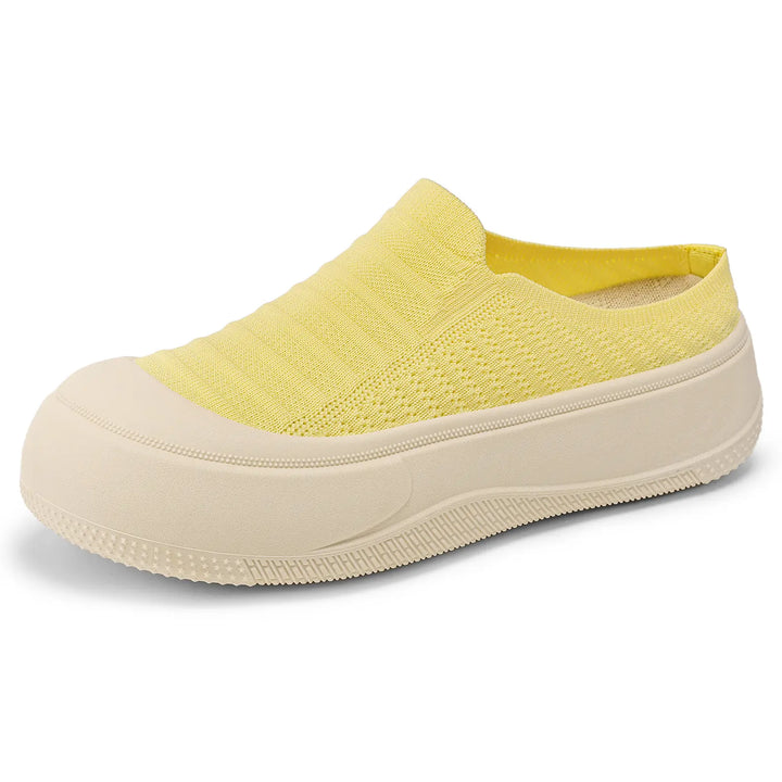 Yellow knit slip-on platform mules for women, featuring a closed round toe and a chunky cream-colored sole, presented in a three-quarter view.