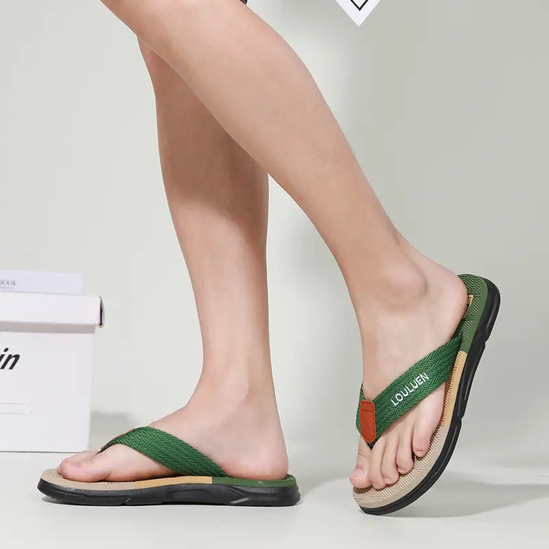 Men's Zemlo flip-flops in green and tan with 'LOULUEN' text on the strap, shown from the side on a studio background.