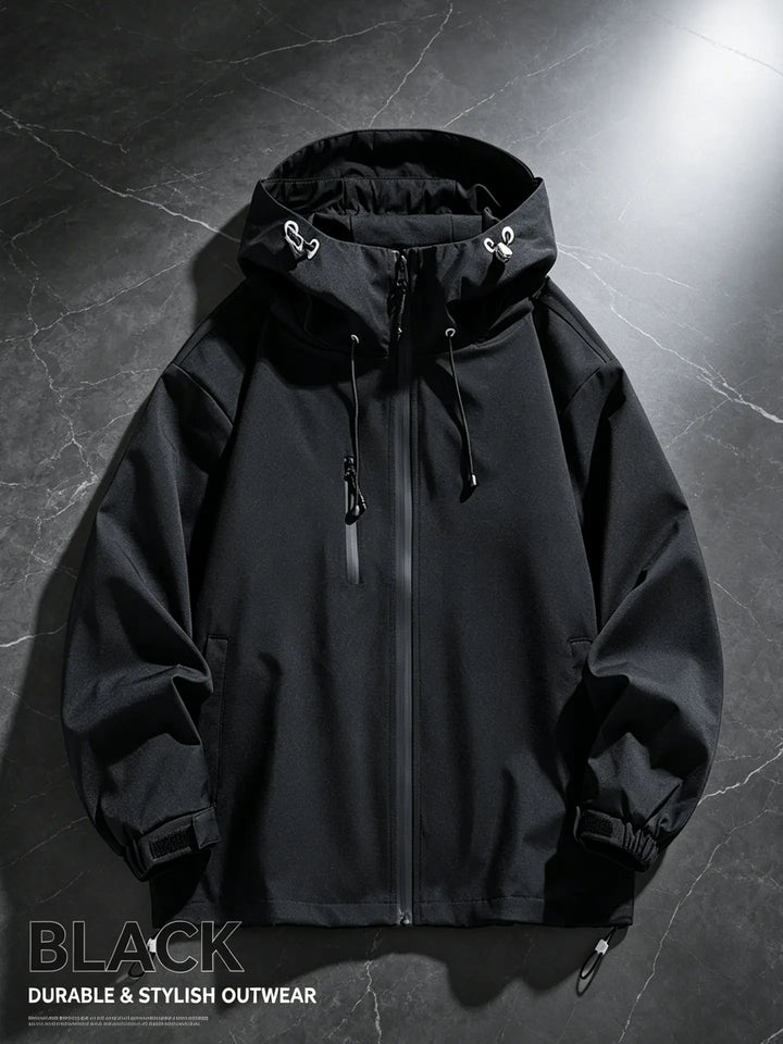 A black Zenthel performance hardshell jacket is shown from the front, featuring a matte finish, adjustable hood with drawstrings, water-repellent zippers on the main closure and pockets, and adjustable cuffs.