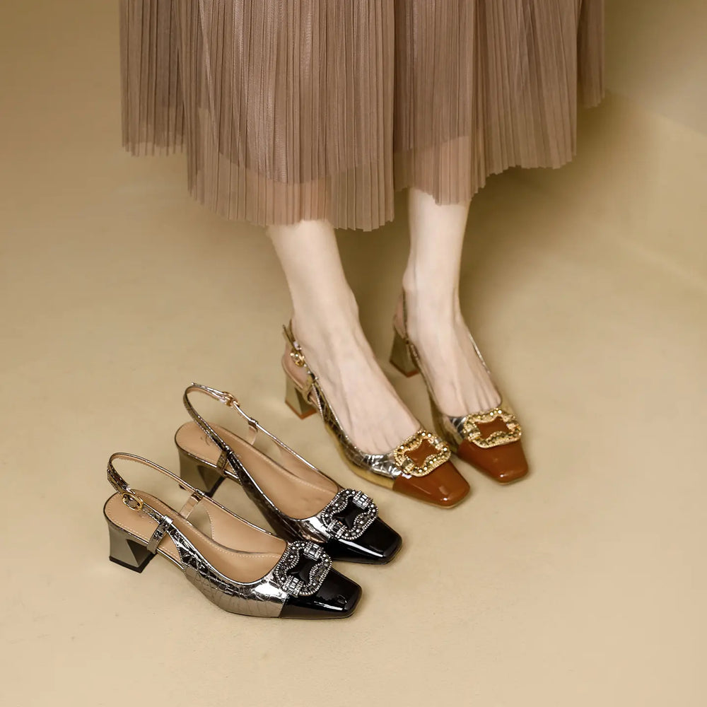 Two pairs of Zephra slingback heels, one in luxe gold with brown patent toe and crystal buckle, the other in chic gunmetal with black patent toe and crystal buckle, shown on a neutral background with a model's legs and skirt.