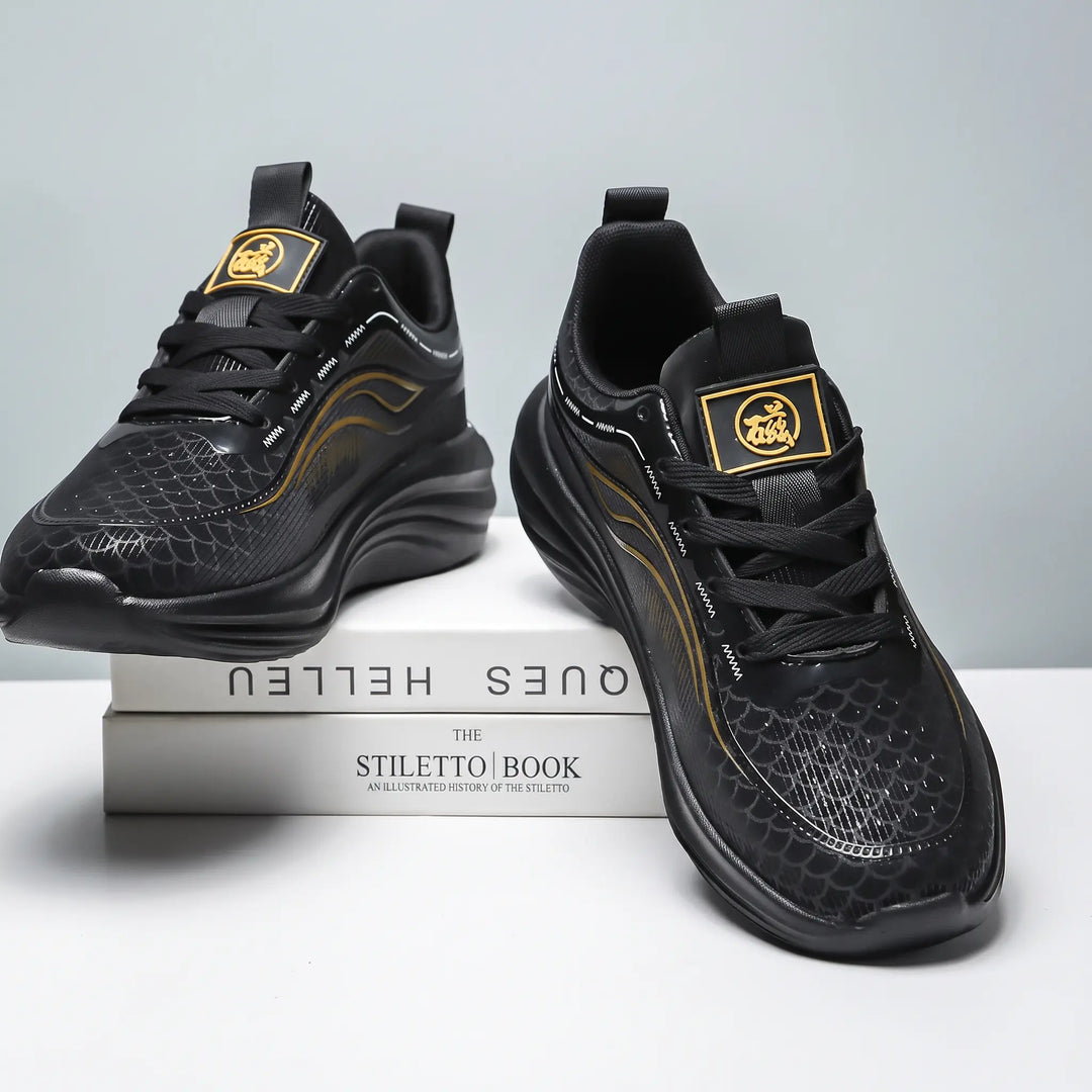 Pair of black Zephyrin lightweight performance sneakers with metallic gold accents, shown from a three-quarter view on top of books, featuring a textured upper and sculpted sole.