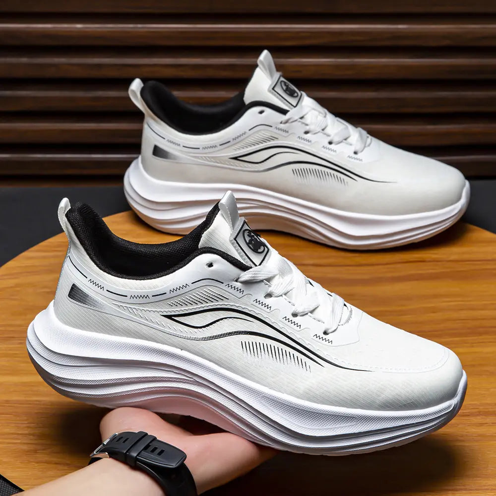 Three-quarter view of Zephyrin white performance sneakers held by a hand, showcasing the engineered mesh upper, sculpted white EVA sole with undulating lines, and black heel collar.