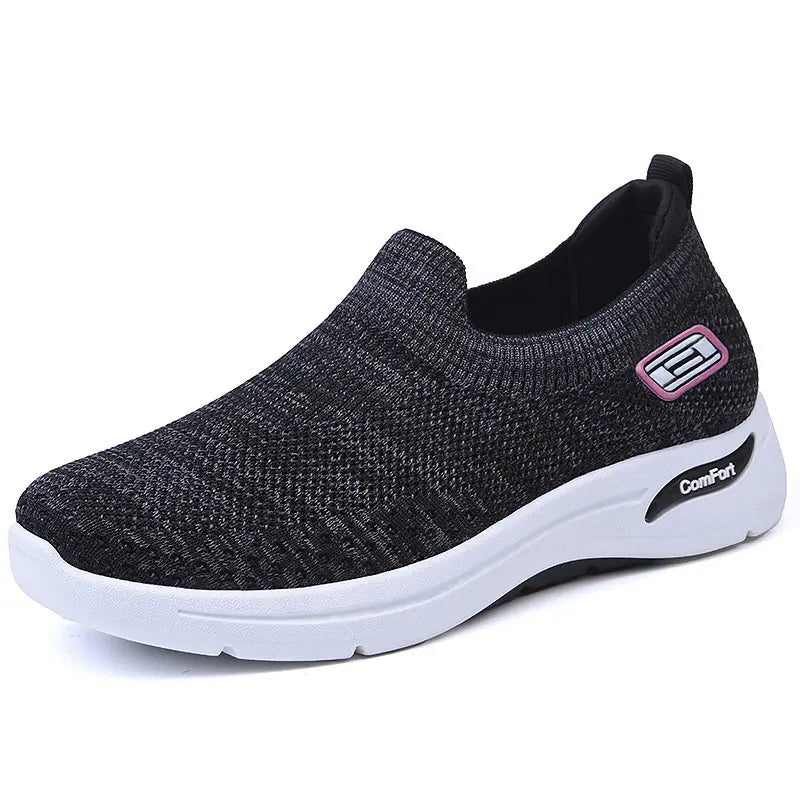 Women's Zephyrine slip-on sneakers crafted from breathable knit mesh in a dark heathered grey, featuring a contrasting white cushioned sole and subtle branding detail on the side. Seen from a three-quarter angle on a white background.