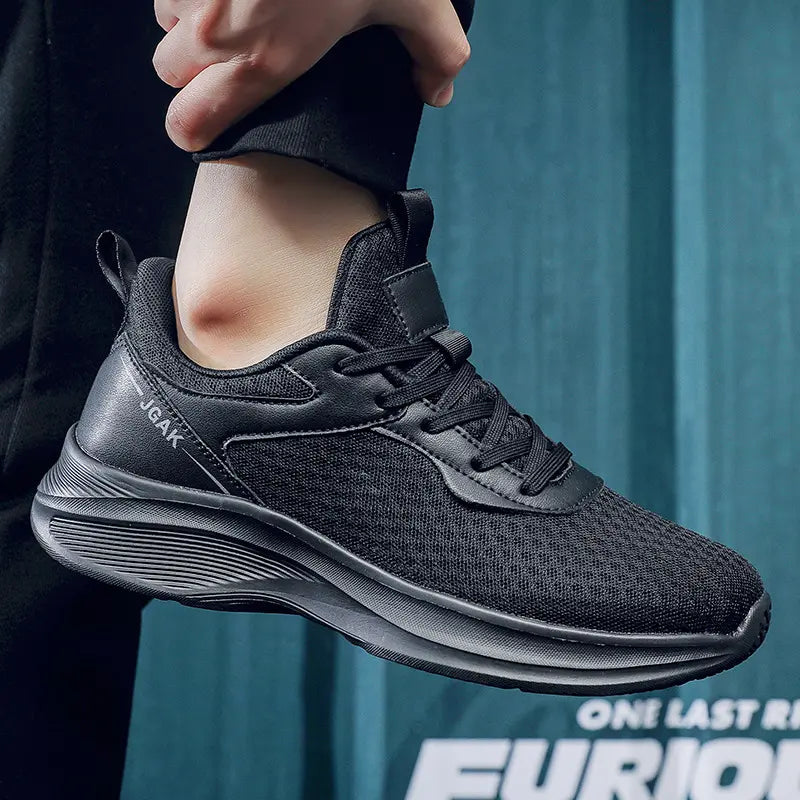 Black ZephyrStride men's casual sneaker shown from the side, worn on a person's foot, featuring breathable mesh and a layered sole.