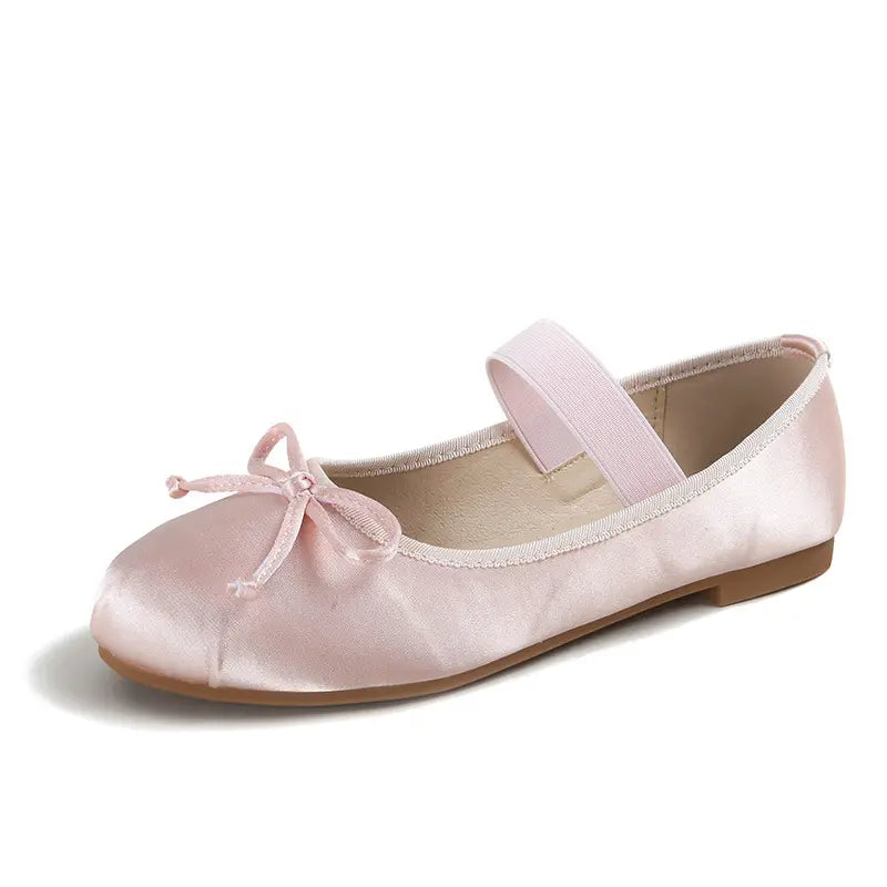 A single Zoryan blush pink satin ballet flat with a delicate bow and elastic instep strap, shown from a three-quarter angle on a clean white background.
