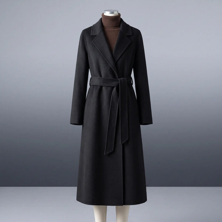 Zoryn black tailored wool midi-length coat with notched lapel and self-tie belt, presented on a mannequin against a neutral studio gradient.