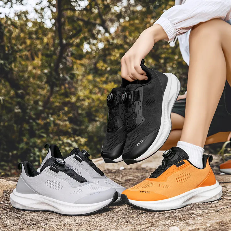 Men's black, grey, and orange Zovian running shoes with rotary buckle closure shown in an outdoor lifestyle setting.