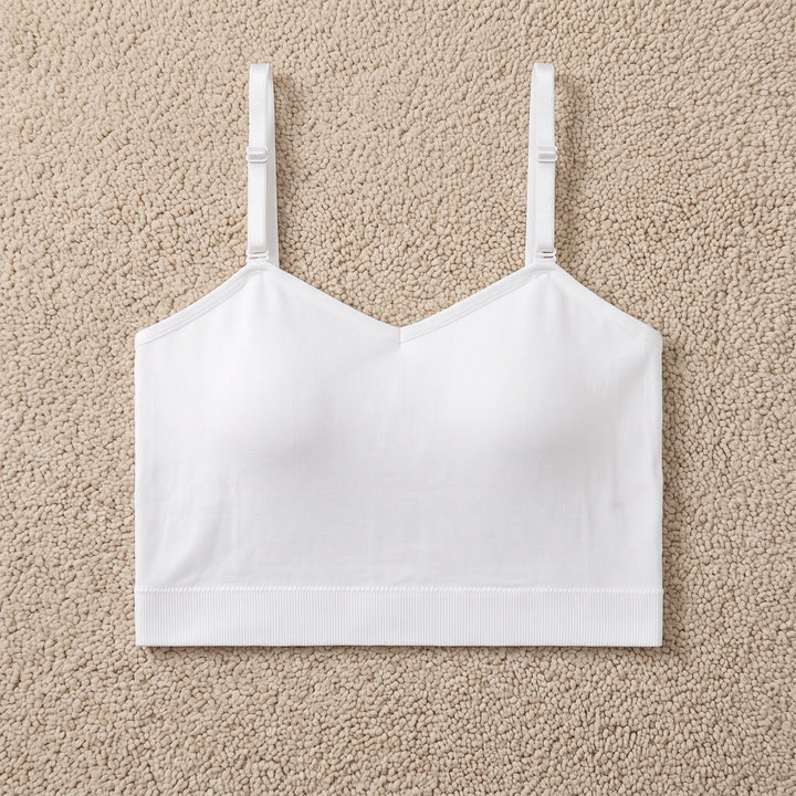 White seamless camisole top with built-in bra, featuring a square neckline and thin adjustable spaghetti straps. This comfortable, cropped garment is made from a fine-ribbed polyamide blend and sits smoothly on the body.