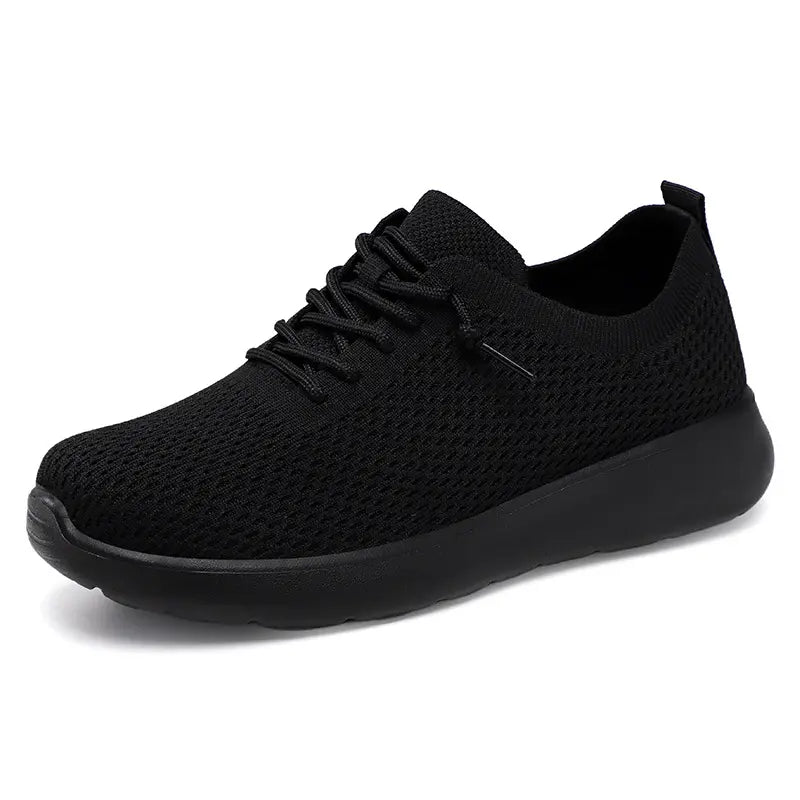 Black Zylo knit trainers with a cushioned black sole and flat lace-up closure, shown from a side view.