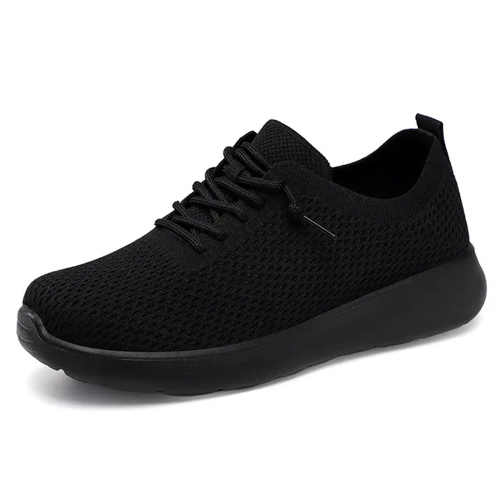 Black Zylo knit trainers with a cushioned black sole and flat lace-up closure, shown from a side view.