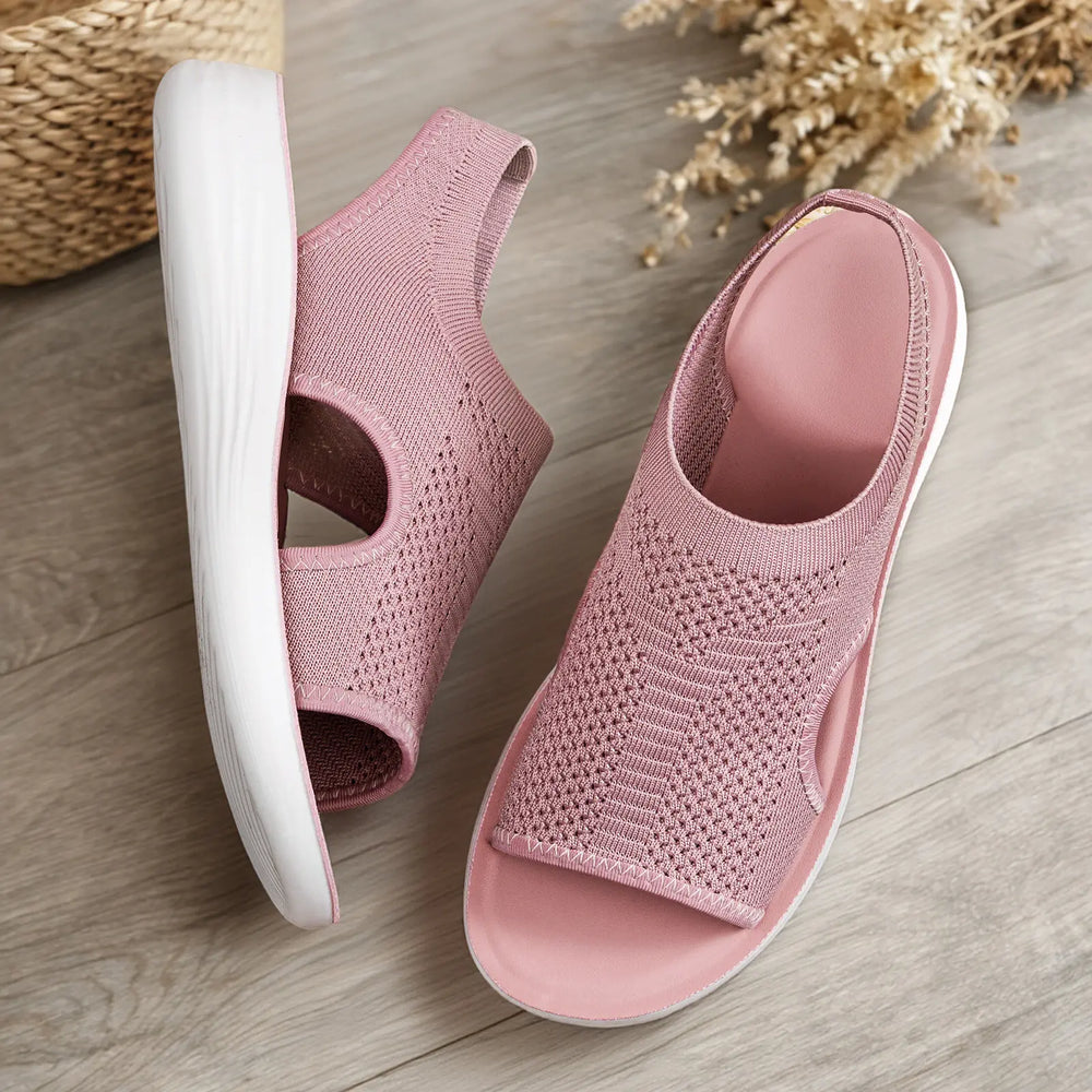 Dusty rose Zyloria women's knit sandals displayed flat-lay on a wooden surface, showcasing their open-toe design, geometric knit pattern, and white contoured soles.