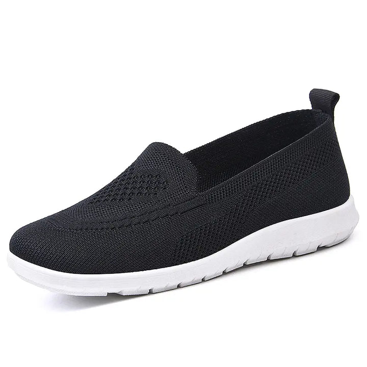 Black Zylos breathable knit slip-on trainers with a subtle diamond weave pattern on the vamp and a clean white sole. Features a round toe and a small heel loop for easy wear.