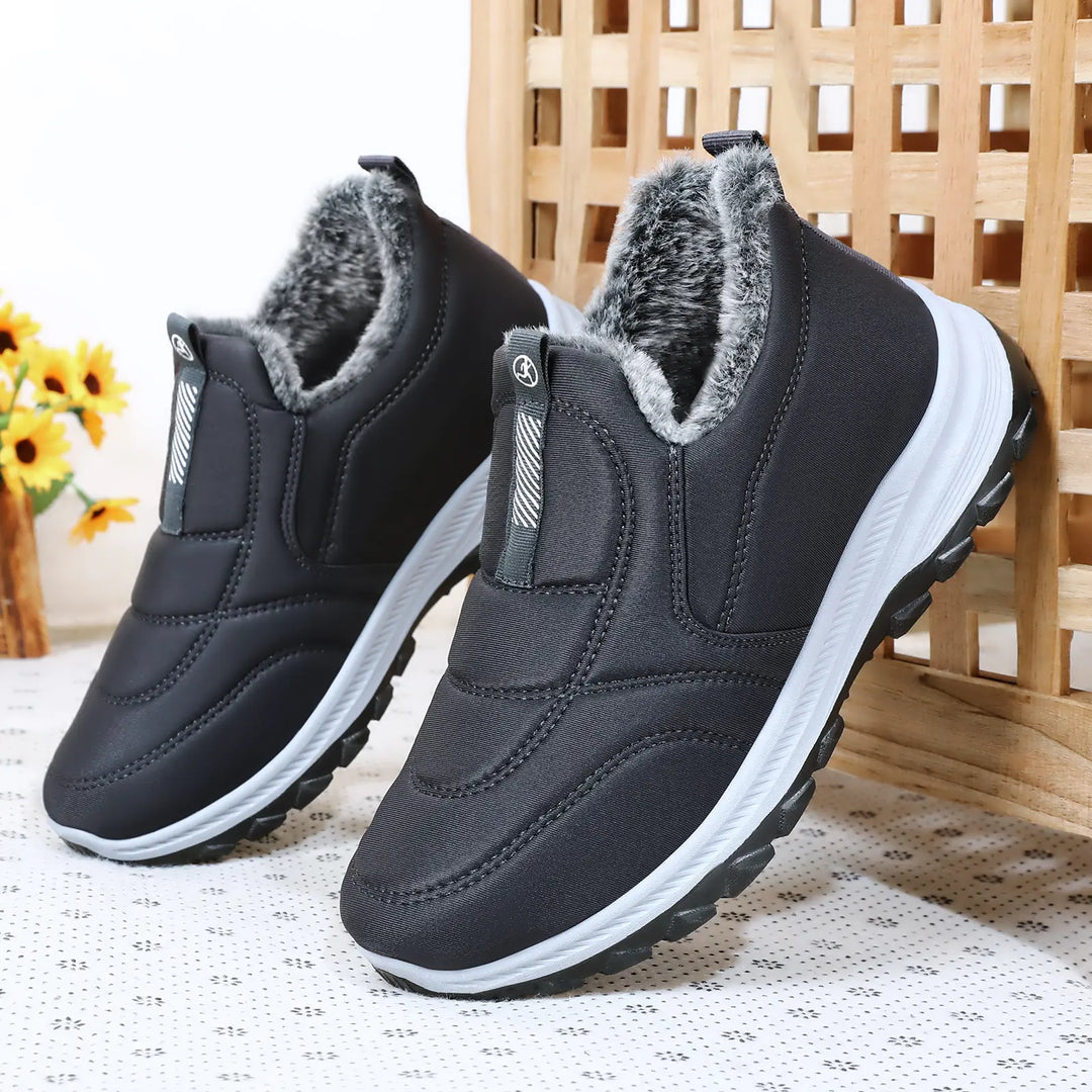 Pair of black Zylos men's warm winter slip-on boots with plush faux fur lining, quilted water-resistant upper, and a durable rubber outsole.