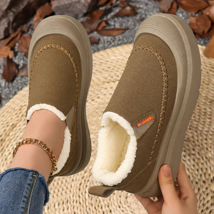 A pair of Zylos comfort boots with plush shearling lining and a chunky grey platform sole, shown on a person&