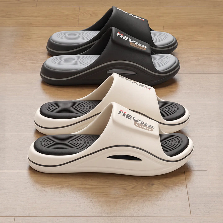 Two pairs of Zylos comfortable EVA slides, one in creamy off-white with a terracotta sole accent, the other in black. Both feature thick sculpted soles and textured wave footbeds, showcasing elevated casual style.