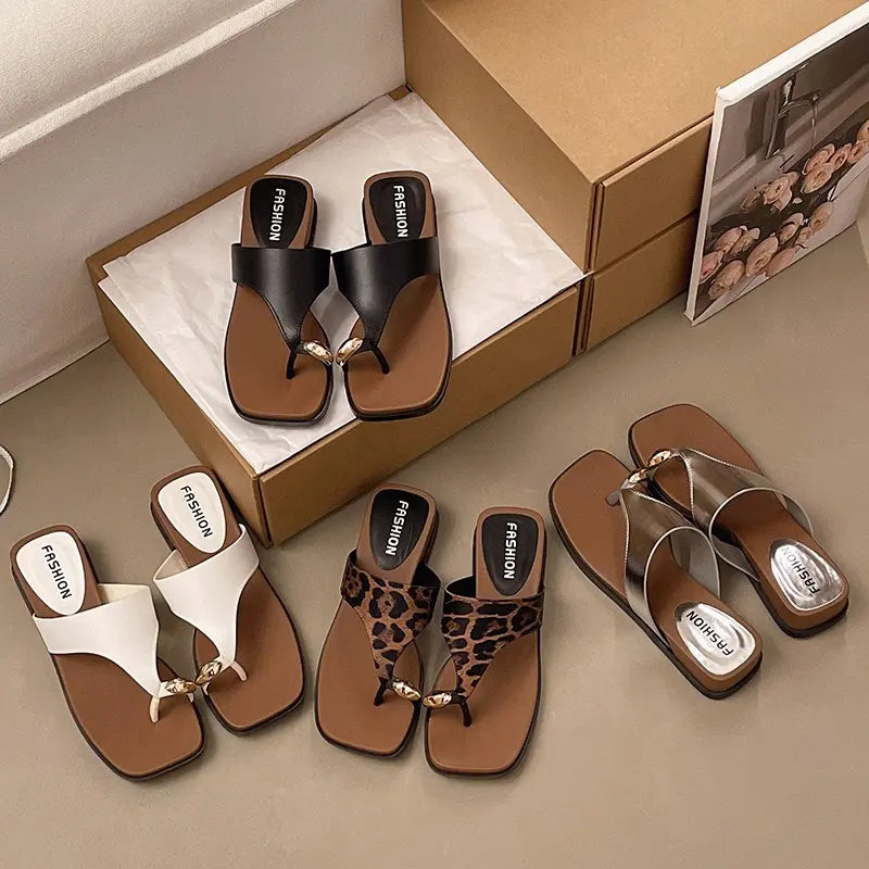 A collection of women's square-toe platform thong sandals featuring leopard print, black, white, and metallic silver straps, presented from a three-quarter angle on a studio background.