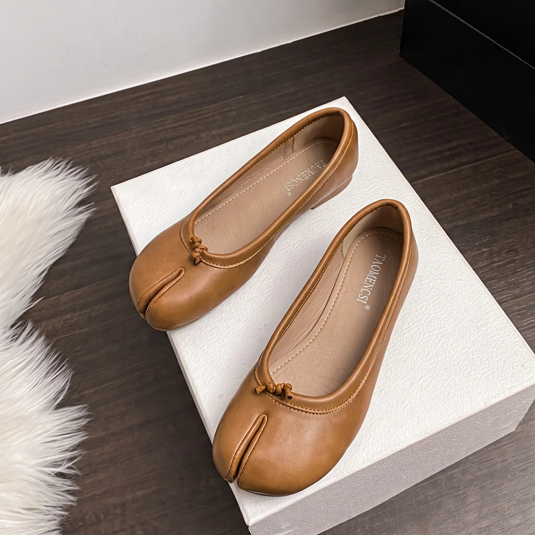 Zylos Split Toe Flats in matte milk tea brown, shown as a pair in a three-quarter view on a white box, showcasing the unique split-toe design and slip-on silhouette.