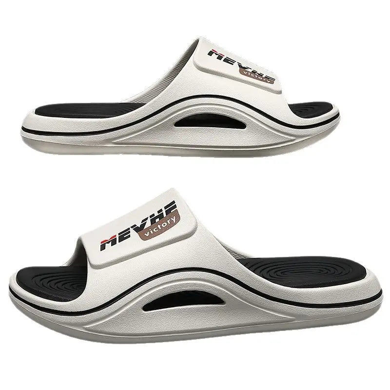 Two white Zylos EVA slides shown from a three-quarter angle, featuring a thick sculpted sole and a textured footbed with 'MEVRHE VICTORY' logo on the strap.