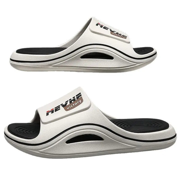 Two white Zylos EVA slides shown from a three-quarter angle, featuring a thick sculpted sole and a textured footbed with &