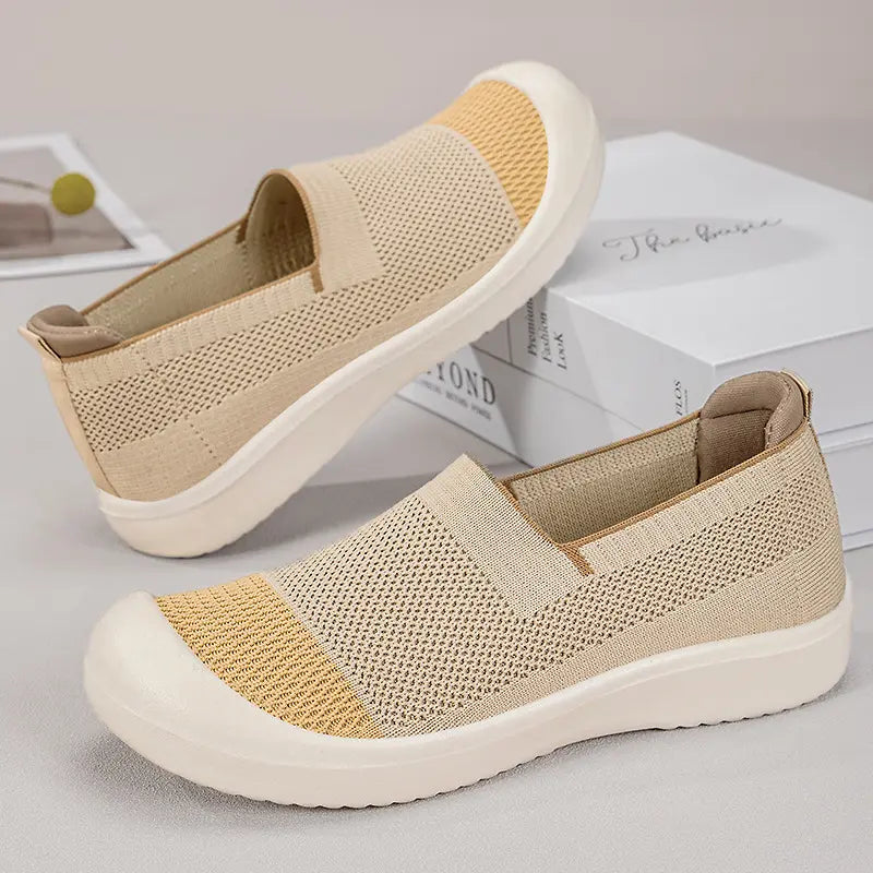 Zylos women's beige knit slip-on shoes with a lighter band across the toe and a creamy off-white sole, shown at a three-quarter angle.