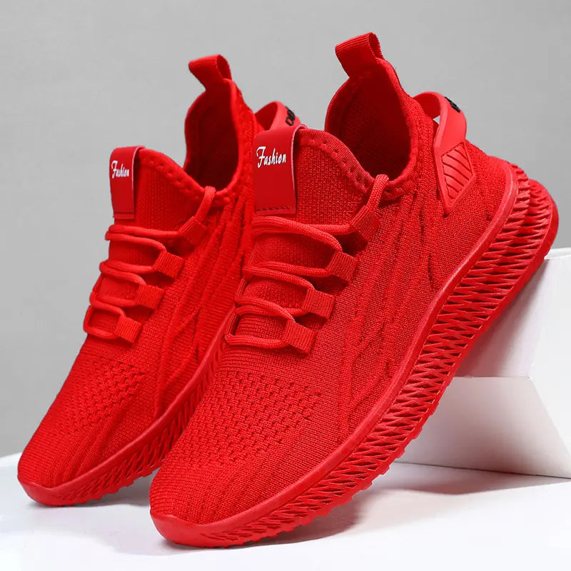 Vibrant red Zylos women's breathable casual sneakers shown from a three-quarter angle, featuring engineered knit mesh uppers and distinctive textured wave soles.