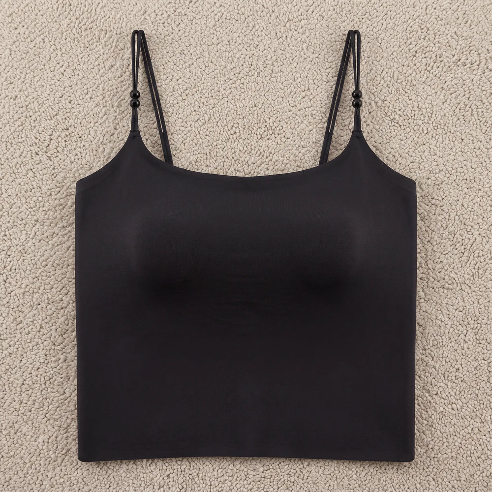 Black seamless camisole featuring integrated 4cm molded cups, delicate adjustable spaghetti straps with pearl accents, and a wide stabilizing hemband for a smooth silhouette.