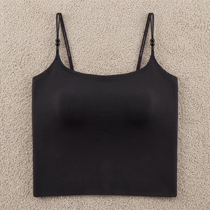 Black seamless camisole featuring integrated 4cm molded cups, delicate adjustable spaghetti straps with pearl accents, and a wide stabilizing hemband for a smooth silhouette.