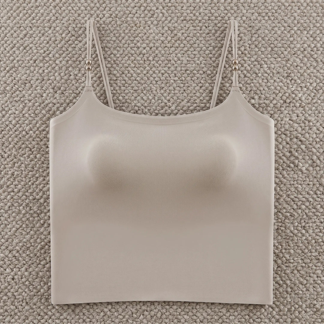 A Zylovo nude seamless camisole with integrated 4cm padded cups and adjustable spaghetti straps featuring pearl accents, presented on a white background.