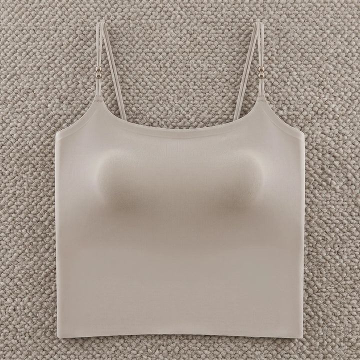 A Zylovo nude seamless camisole with integrated 4cm padded cups and adjustable spaghetti straps featuring pearl accents, presented on a white background.