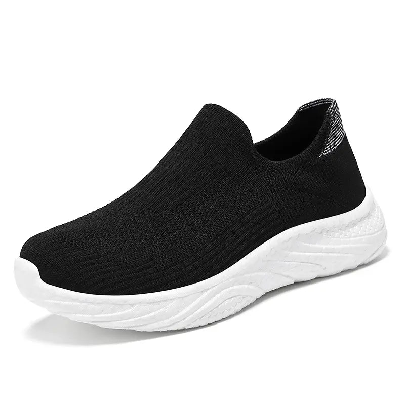 Black Zylpha casual slip-on sneaker with a breathable engineered knit upper and a white sculpted EVA foam sole, shown from a side profile view.