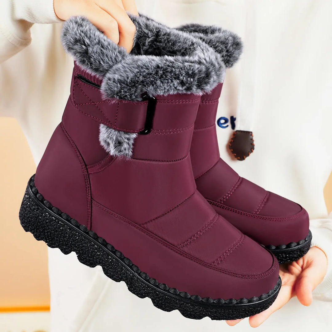Zylvaia quilted burgundy mid-calf winter boots featuring plush faux fur lining, an adjustable side strap with a matte black buckle, and a chunky lugged rubber sole.