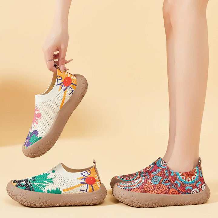 Zyra artistic print slip-on flats showcased with bohemian and graffiti patterns, featuring breathable knit uppers and flat taupe soles.