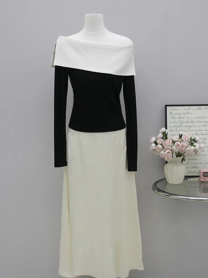 Zythos asymmetrical knit top in black and optic white, featuring a striking off-shoulder neckline and long sleeves.